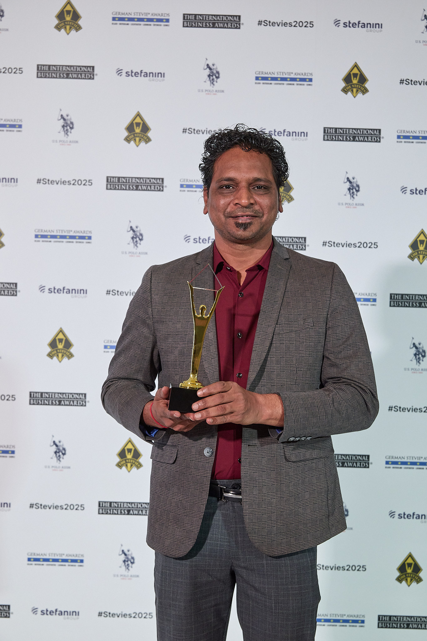 Chirag Patel holding Stevie Award trophy at ceremony in Lisbon, Portugal 2025